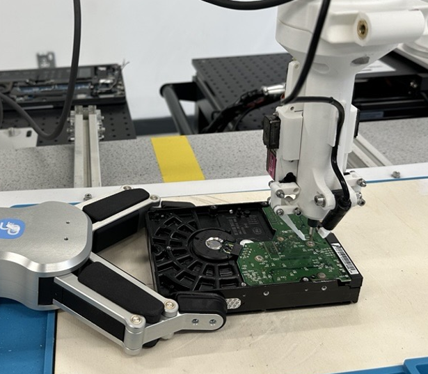 Robotic tooling arm working on an electronic device